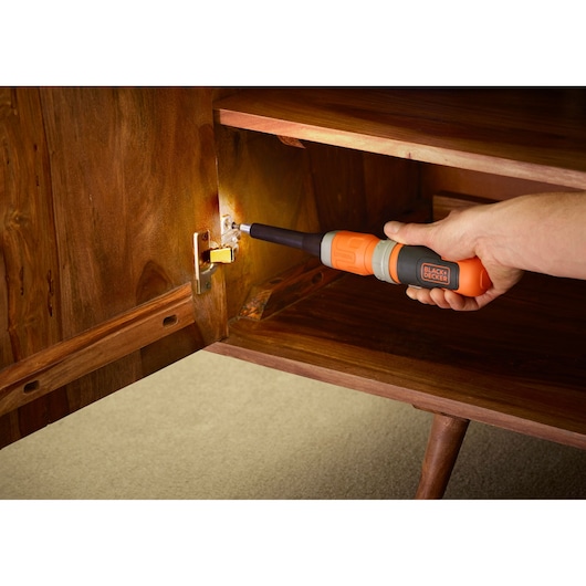 BLACKDECKER BCF603C cordless screwdriver used on cabinet hinge in home setting.