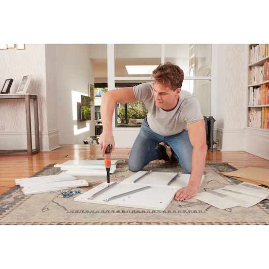 BLACKDECKER BCF603C cordless screwdriver in use assembling furniture indoors, product category Photography.