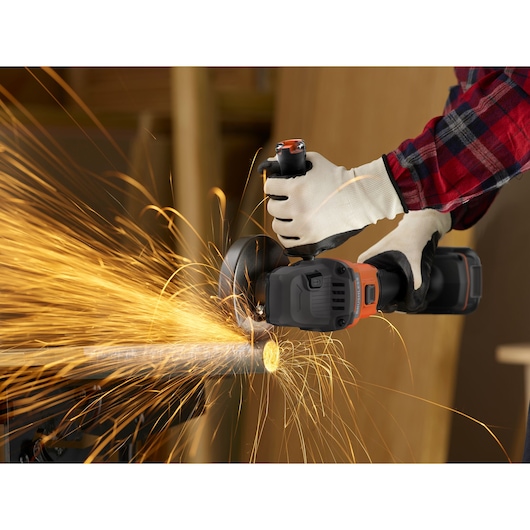 Photo of BLACKDECKER BCG6L8D2S angle grinder in use, cutting metal pipe with sparks flying, close-up view.