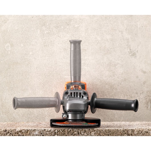BLACK+DECKER BCG720M1 angle grinder front view on concrete surface, three-position handle, silver and black.