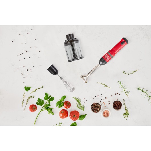 BLACKDECKER BCKM1013KR hand blender set with whisk, chopper attachment, red handle, top view with herbs and tomatoes.