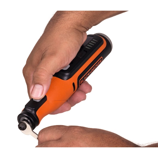 Photo of BLACK+DECKER BCRT8IK orange and black rotary tool in use, close-up of hands operating tool.
