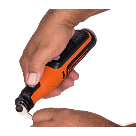 Photo of BLACKDECKER BCRT8I orange cordless rotary tool held in hand, side angle, tool in use.