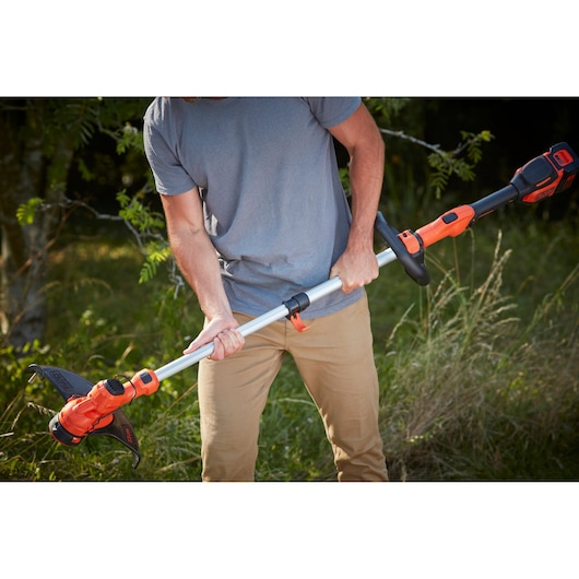 Photo of BLACKDECKER cordless grass trimmer BCSTA536L1 being used outdoors, orange and black design.