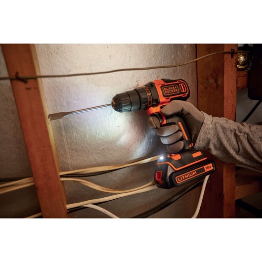 BLACKDECKER BDCDD186K cordless drill in use, 18V lithium-ion, photographed during wall installation.