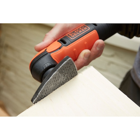 BLACKDECKER BDCDS12N sander in use on light wood surface, close-up photography.