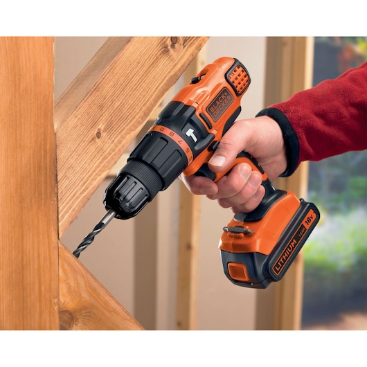 BLACKDECKER BDCH188N cordless drill in use on wood, orange and black color, lateral angle.