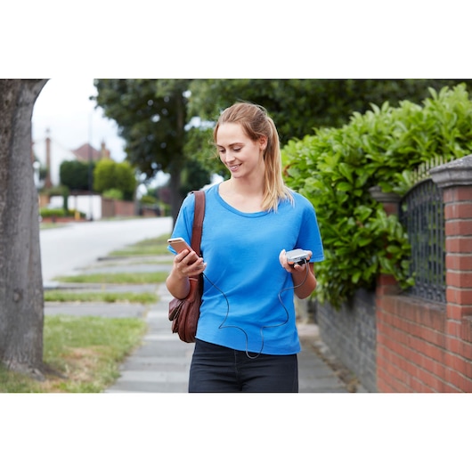 BLACKDECKER BDCHD12S1 photography of a person walking outside holding a phone and portable device with earphones.
