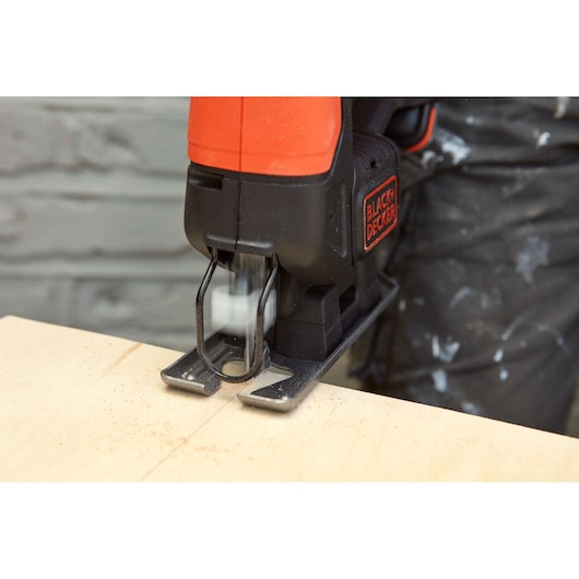 BLACKDECKER BDCJS12N jigsaw cutting wood, close-up of blade and base.