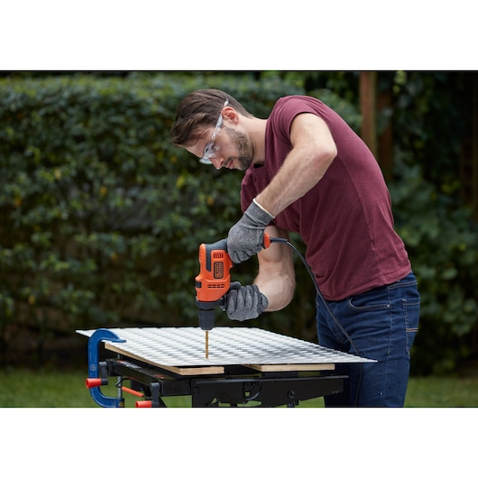 BLACKDECKER BEH200K corded drill used for woodworking outdoors, gloves and safety glasses worn.
