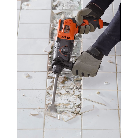 BLACKDECKER BEHS01 rotary hammer used to remove white tile, close-up action on damaged tiles.