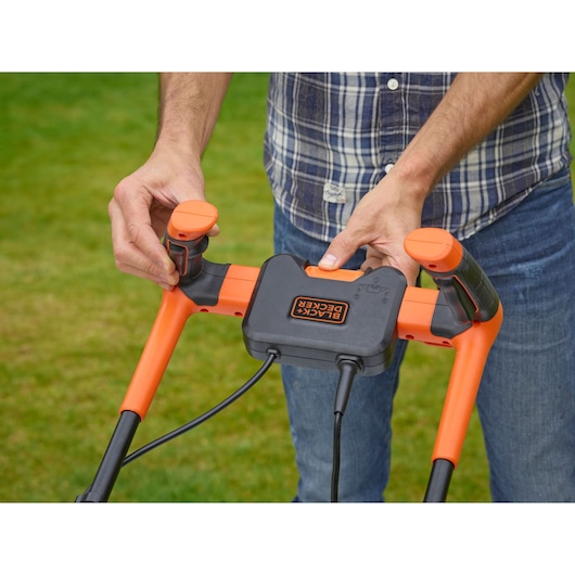 BLACKDECKER BEMW451BH lawn mower handle controls close-up outdoors.