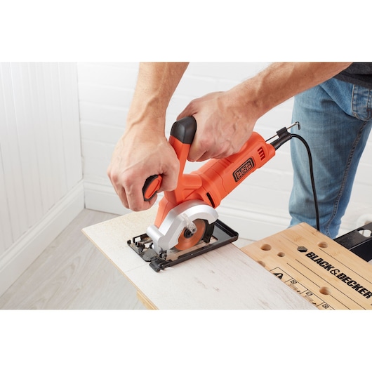 BLACK+DECKER BES510K mini circular saw cutting wood, close-up action shot.
