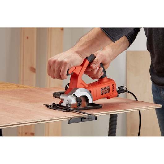 BLACK+DECKER BES510K compact circular saw cutting plywood, handheld close-up view.
