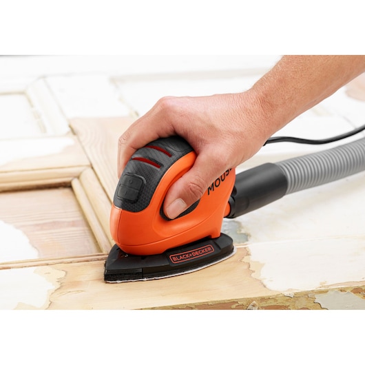 BLACKDECKER BEW230K compact orange mouse sander sanding wooden surface, close-angle photo