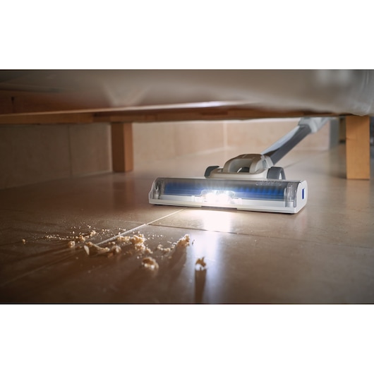 BLACKDECKER BHFEA420J vacuum cleaner head with LED light cleaning crumbs under furniture on tile floor