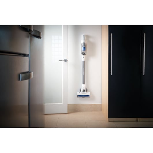 BLACKDECKER BHFEA420J cordless stick vacuum cleaner mounted on a wall in a modern kitchen.