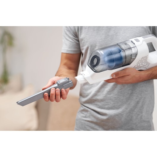 Photo of BLACKDECKER BHFEA420J handheld vacuum with gray nozzle attachment being inserted.