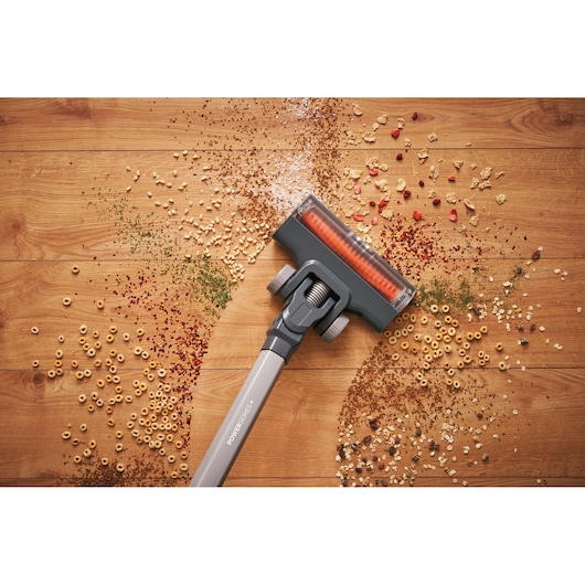 BLACKDECKER BHFEA520J stick vacuum cleaning debris from wooden floor, top view photography