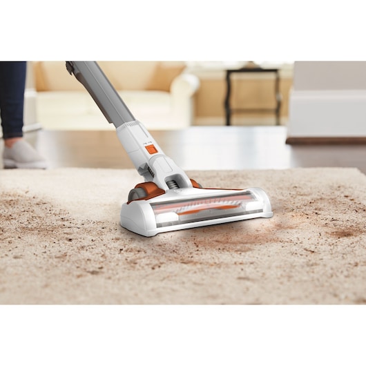BLACKDECKER BHFEV1825C cordless vacuum cleaner cleaning beige carpet, close-up angle.