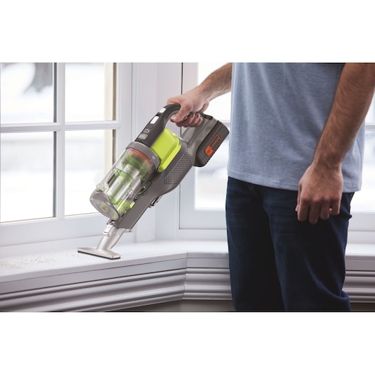 BLACKDECKER BHFEV362DA cordless vacuum cleaner used on white window sill.