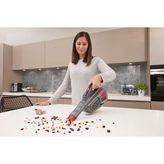 BLACKDECKER BHHV315J handheld vacuum cleaning crumbs on a kitchen counter.
