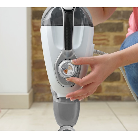 BLACKDECKER BHSM1615DSG steam mop control knob close-up, hand adjusting settings, indoor use.