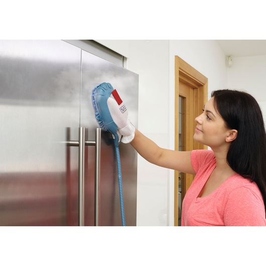 BLACKDECKER BHSM1615DSG steam cleaning glove used on stainless steel fridge door.