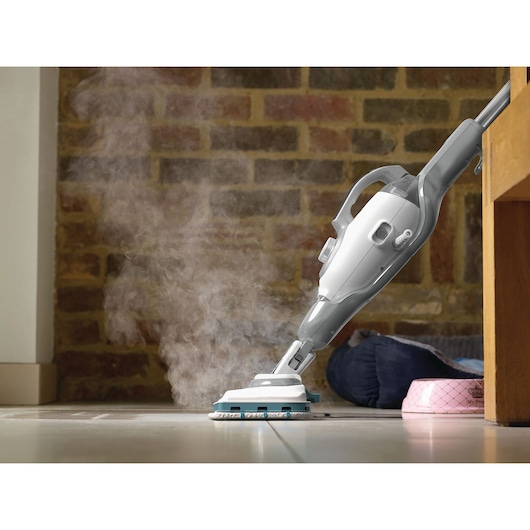 BLACK+DECKER BHSM1615DSG steam mop cleaning tile floor, close-up side view with visible steam.