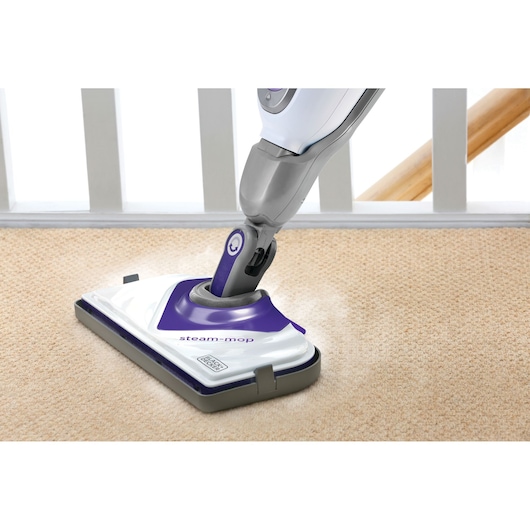 BLACKDECKER BHSM1615DSM steam mop cleaning beige carpet, close-up view of mop head in use.