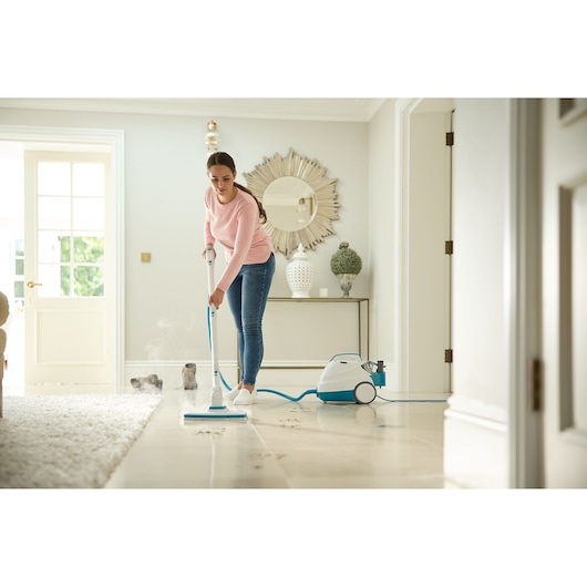 Photo of BLACKDECKER BHSMP2008 steam mop cleaning muddy footprints on tile floor in a modern home setting.