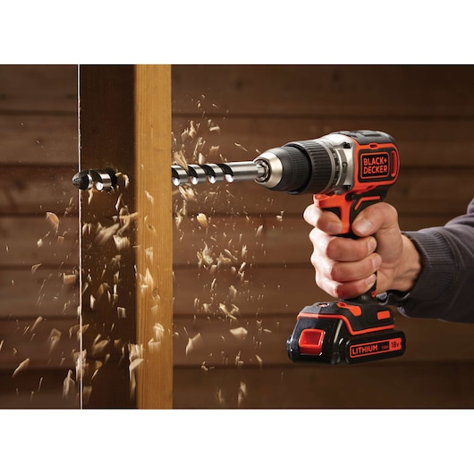 BLACKDECKER BL188K cordless drill in use, drilling through wood, photography of sawdust flying.