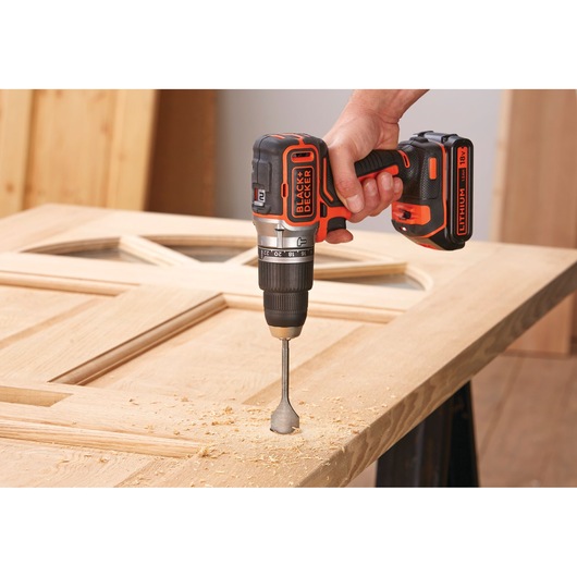 BLACKDECKER BL188N cordless drill in use drilling into wooden door, close-up photography.