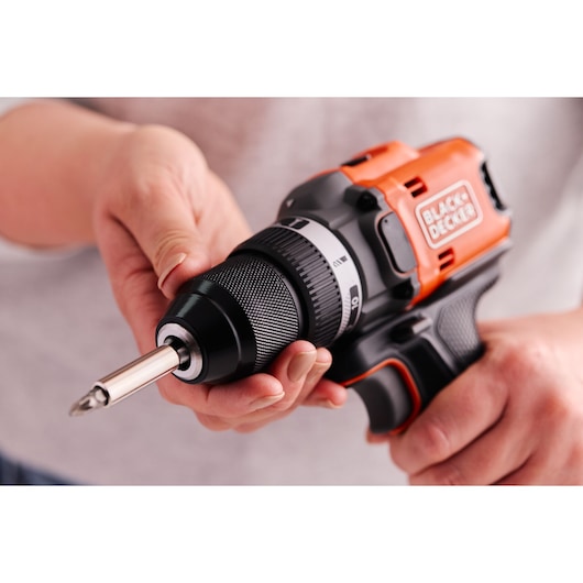 Close-up photo of BLACK+DECKER cordless drill BLD682D1, orange and black, held in hands, visible bit attachment.