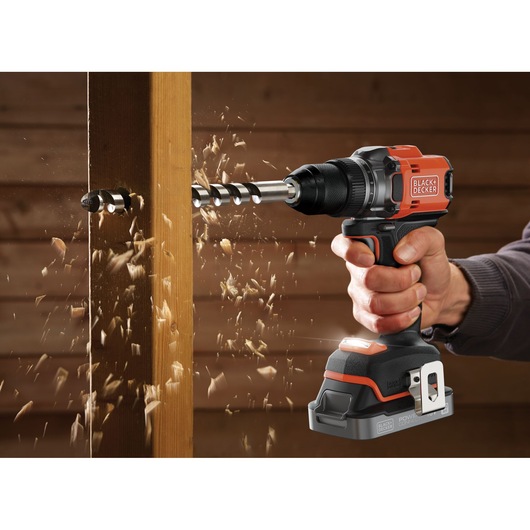 BLACKDECKER BLD682XN cordless drill in use, drilling into wooden beam with wood chips flying.
