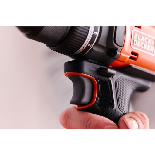 Close-up photo of BLACK+DECKER BLD682XN drill handle and trigger in hand, showing textured black and orange grip.