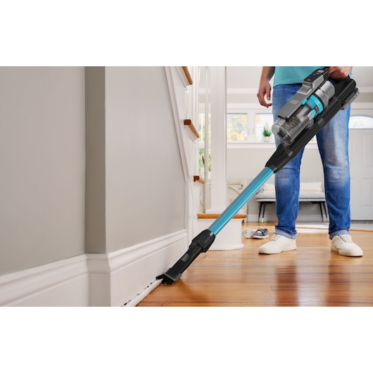 BLACKDECKER BSV520BRB stick vacuum cleaning floor edges in a modern home, blue and black design.