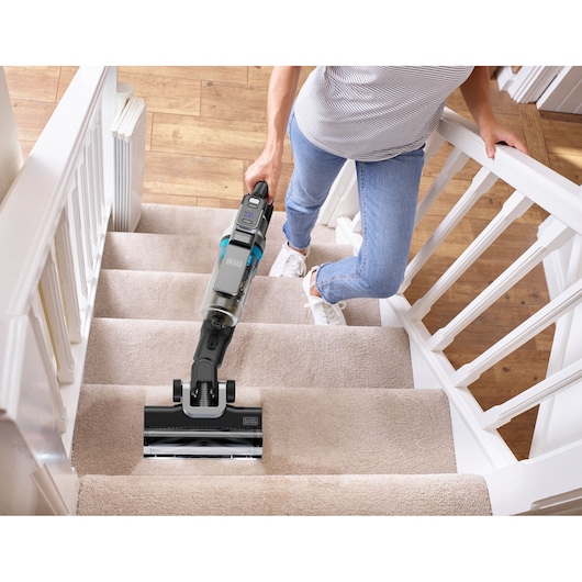 BLACKDECKER BSV520BRB cordless stick vacuum used to clean carpeted stairs, shown from above.