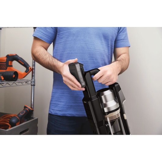 BLACKDECKER BSV525BLP cordless vacuum cleaner, close-up side view of person inserting battery.