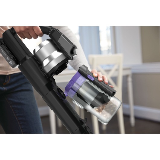 BLACK+DECKER BSV525BRP cordless vacuum cleaner with dust container being removed, close-up indoor setting.