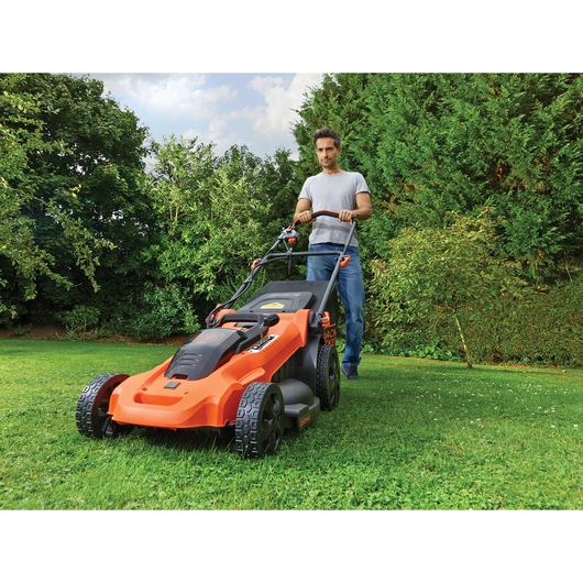 BLACKDECKER CLMA4825L2 orange cordless lawn mower in use on grass outdoors, product photography
