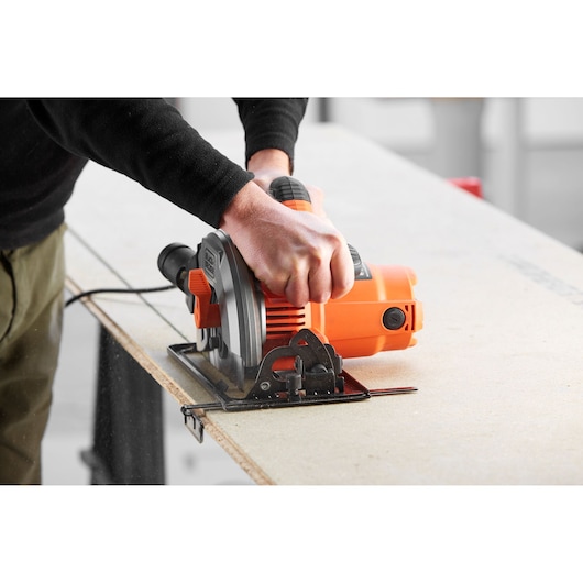BLACKDECKER CS1550 circular saw cutting wood, close-up side angle, orange and black power tool.