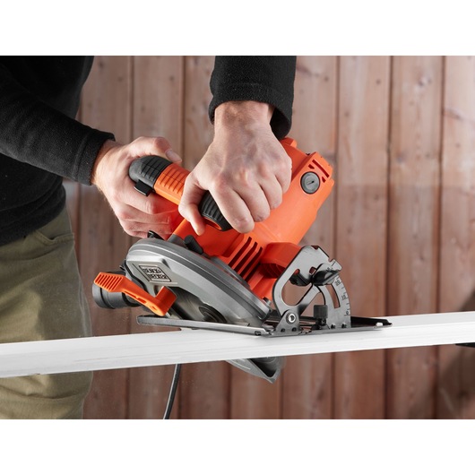 BLACKDECKER CS1550 circular saw in use cutting wood, close-up view showing grip and blade.
