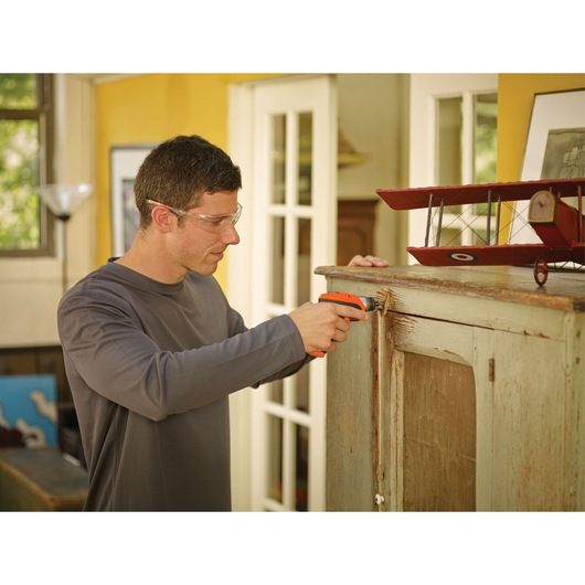 BLACKDECKER CS3652LC cordless screwdriver used on cabinet indoors, with model airplane on top.