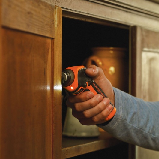 Photo of BLACKDECKER CS3652LC cordless screwdriver used on a wooden cabinet indoors.