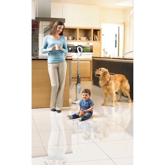 BLACKDECKER FSM16CD steam mop in modern kitchen with adult, child, and dog on clean tile floor.