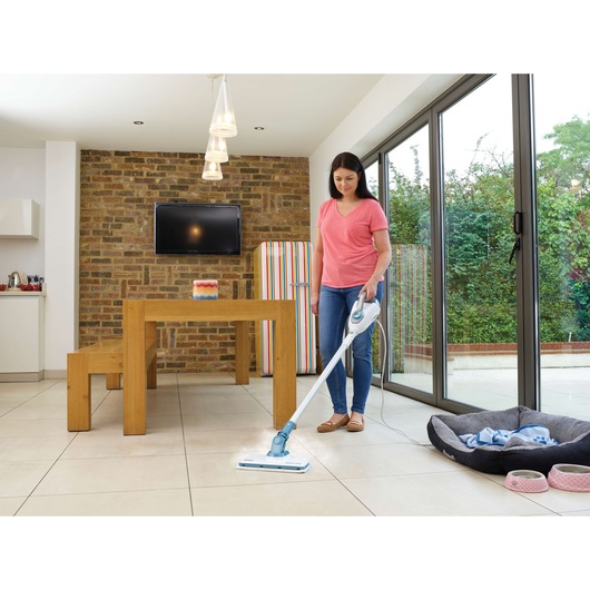 BLACKDECKER FSMH1300FX steam mop cleaning tile floor in modern kitchen, photography with user.