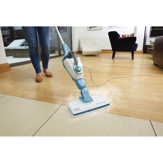 BLACKDECKER FSMH1321 steam mop cleaning hardwood and tile floor in a modern living room setting.