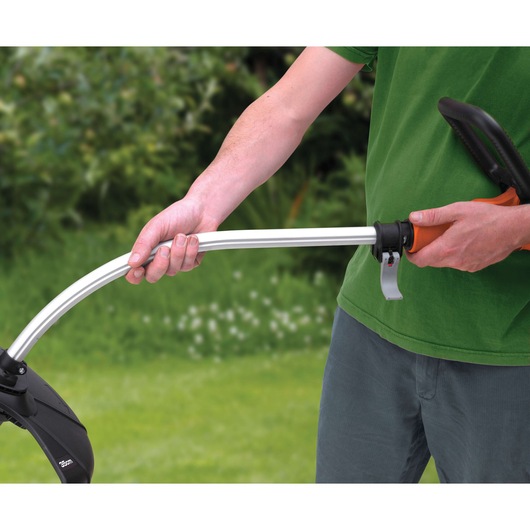 BLACKDECKER GL9035 grass trimmer handle with curved silver shaft held by person in green shirt, outdoor setting.