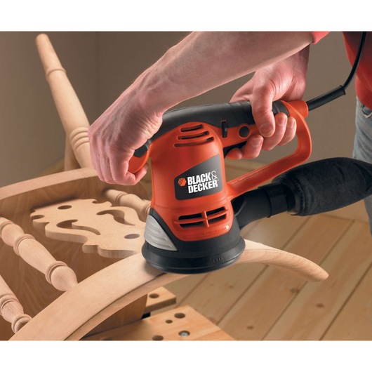 Photo of BLACK+DECKER KA191EK electric sander being used to sand wooden furniture.